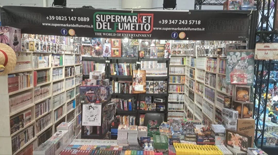 Lo stand del Supermarket del Fumetto a una fiera, allestito con manga e gadget